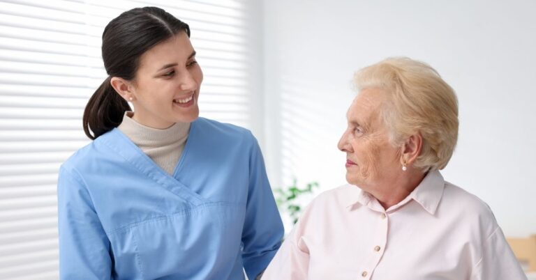 a caregiver smiling to her patient at memory care