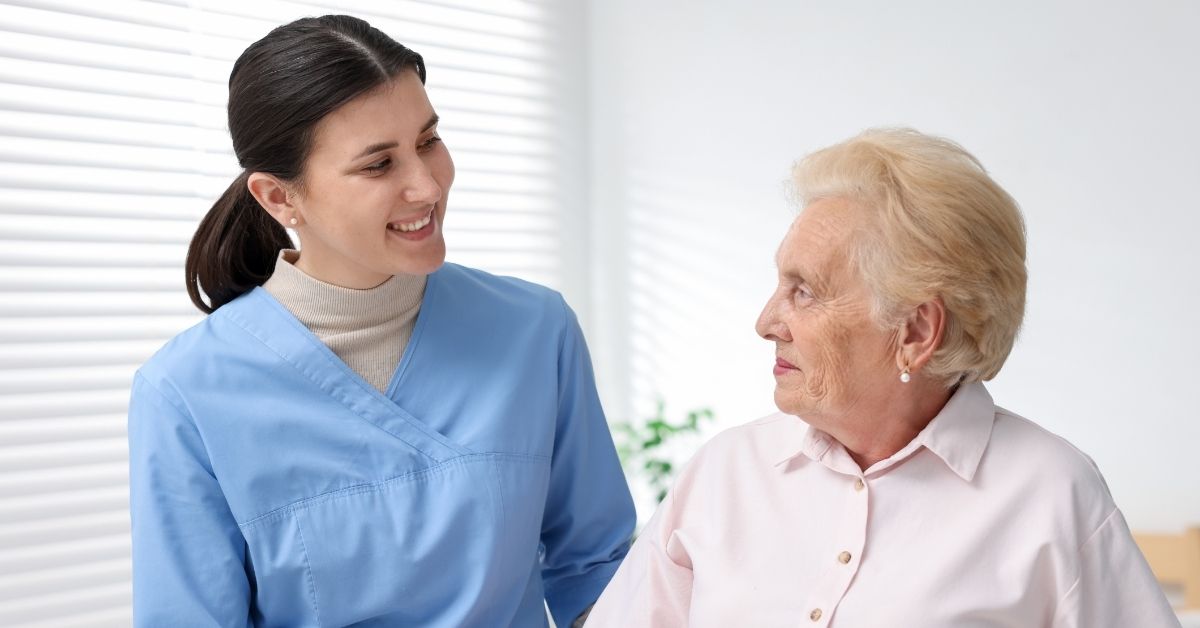 a caregiver smiling to her patient at memory care