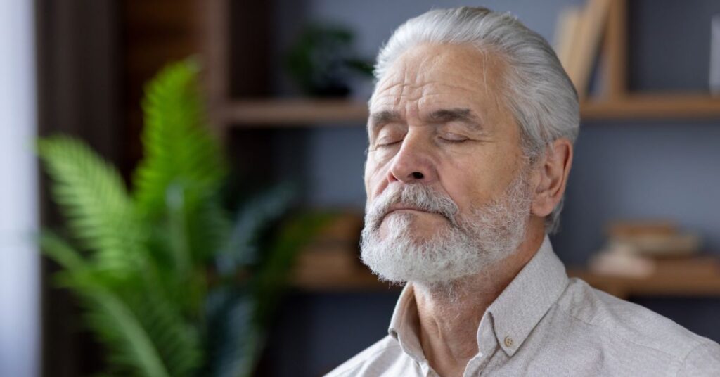 an elderly man doing his mindfulness breathing therapy at assisted living
