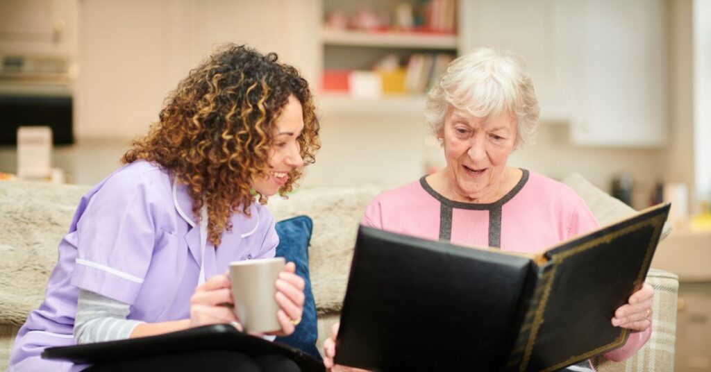 a senior lady reading next to her caregiver