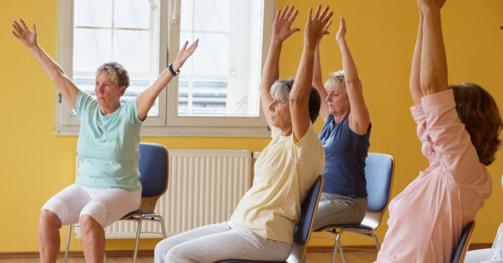 a group of senior ladies in a yoga chair class
